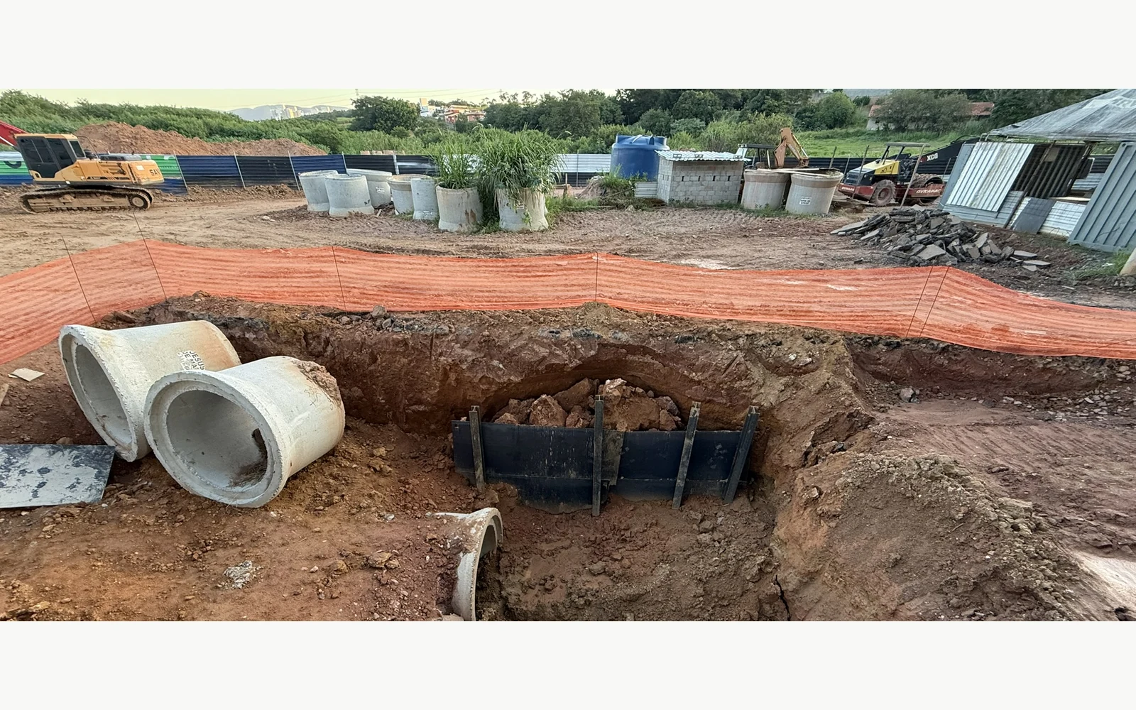 Escavação de vala com tubulações, contenção temporária e frente de obra
